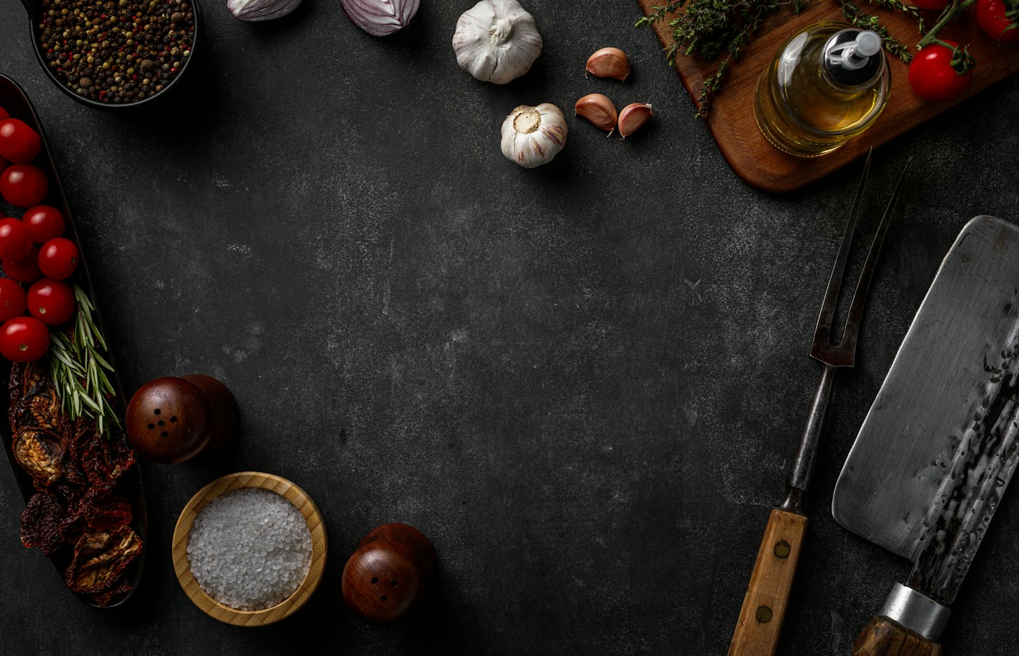 Fresh cooking ingredients and kitchen tools arranged on stone surface.